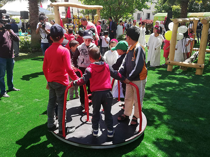 Children playing on the Merry Roundabout in a Moroccan Orphanage Play Area